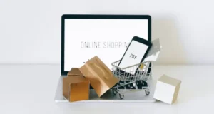 Carrinho de compras miniatura sobre laptop, representando compra online em loja virtual ou marketplace.